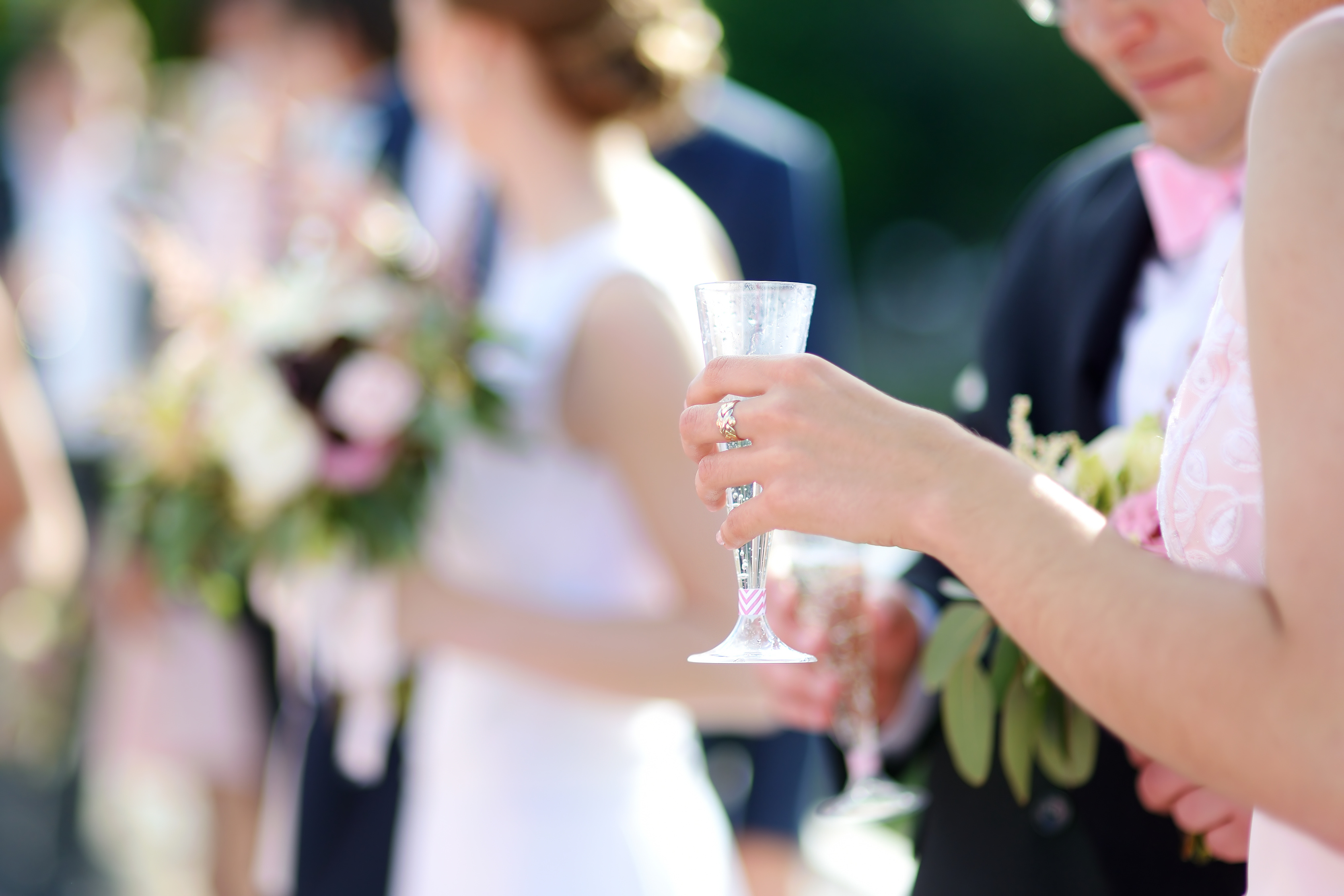 Woman holding a glass of champagne at some festive event, party or wedding reception
