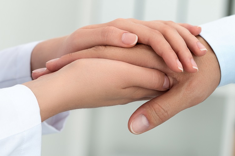 Female medicine doctor reassuring her patient. Hands close-up. Healthcare and medical concept.